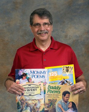photo of John J. Micklos Jr. with some of his published books